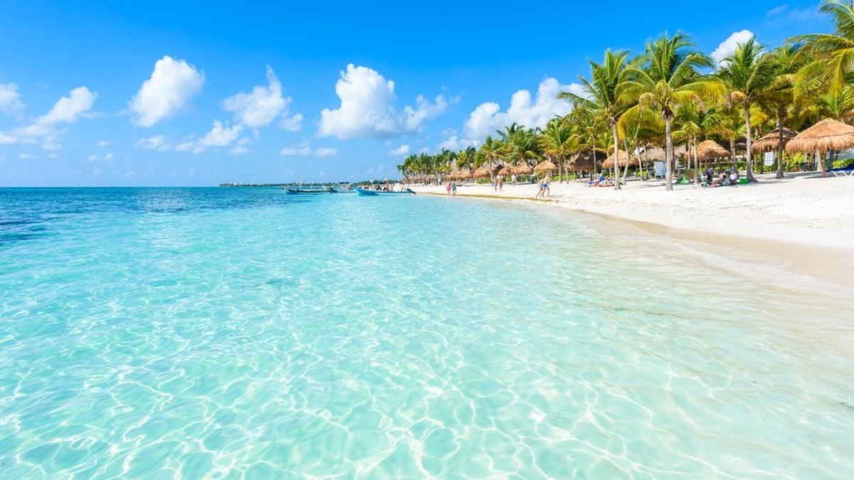 Soliman Bay near Tulum with crystal clear turquoise water and palm-lined white sand beach