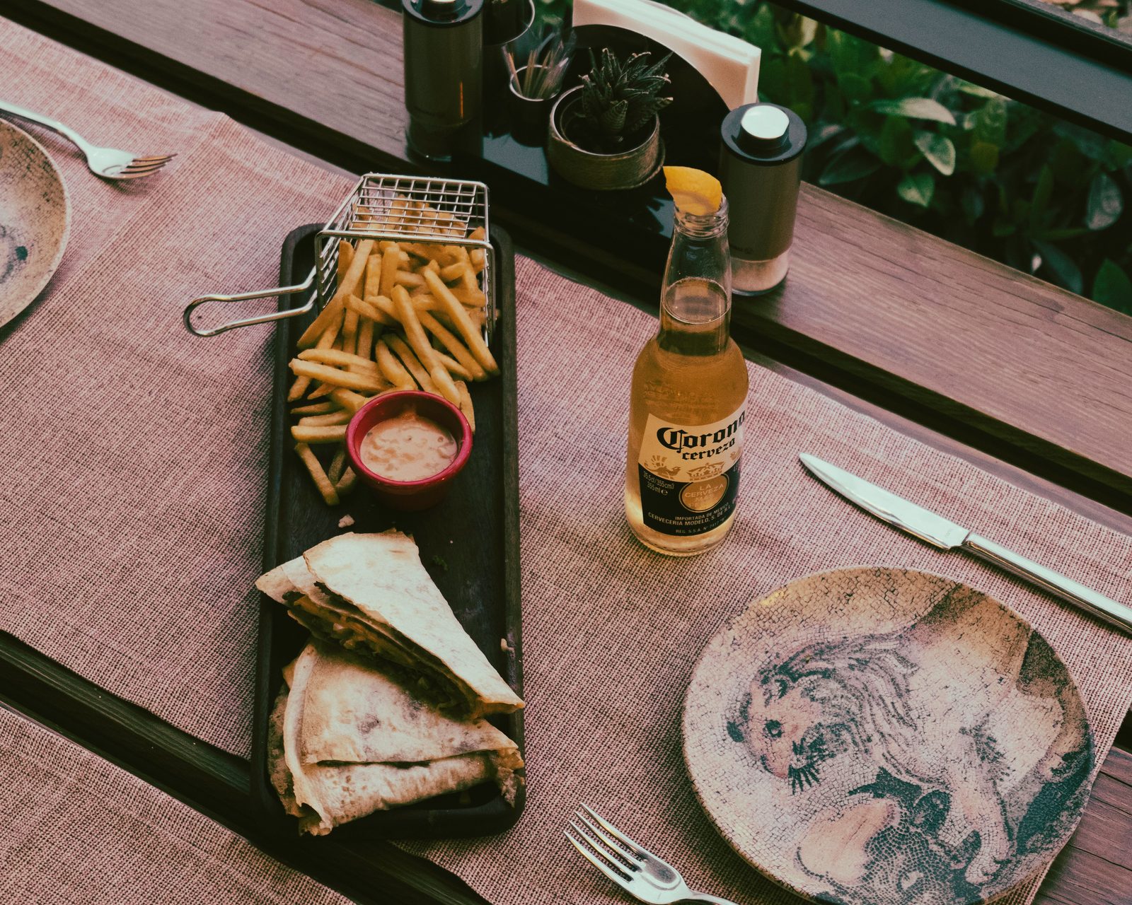 Quesadillas with fries and a cold beer set on a Tulum restaurant table