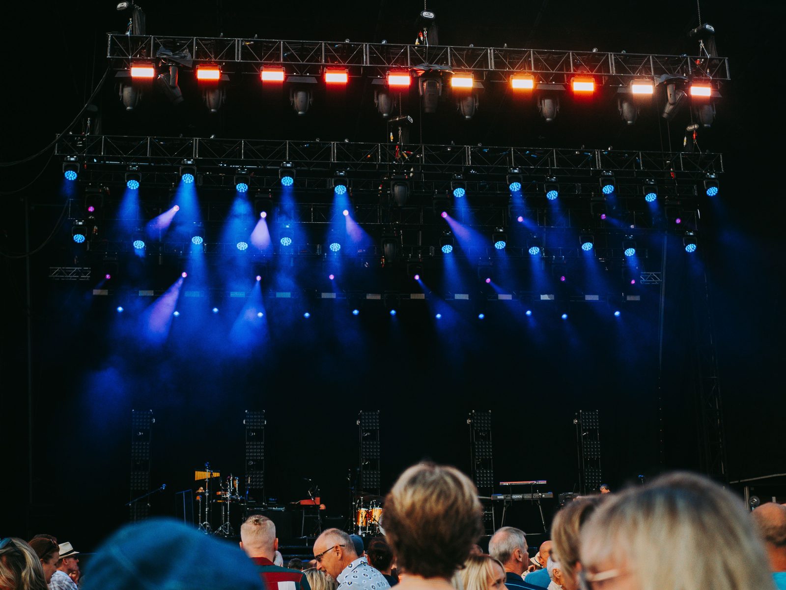 Stage lighting over a night-time festival audience