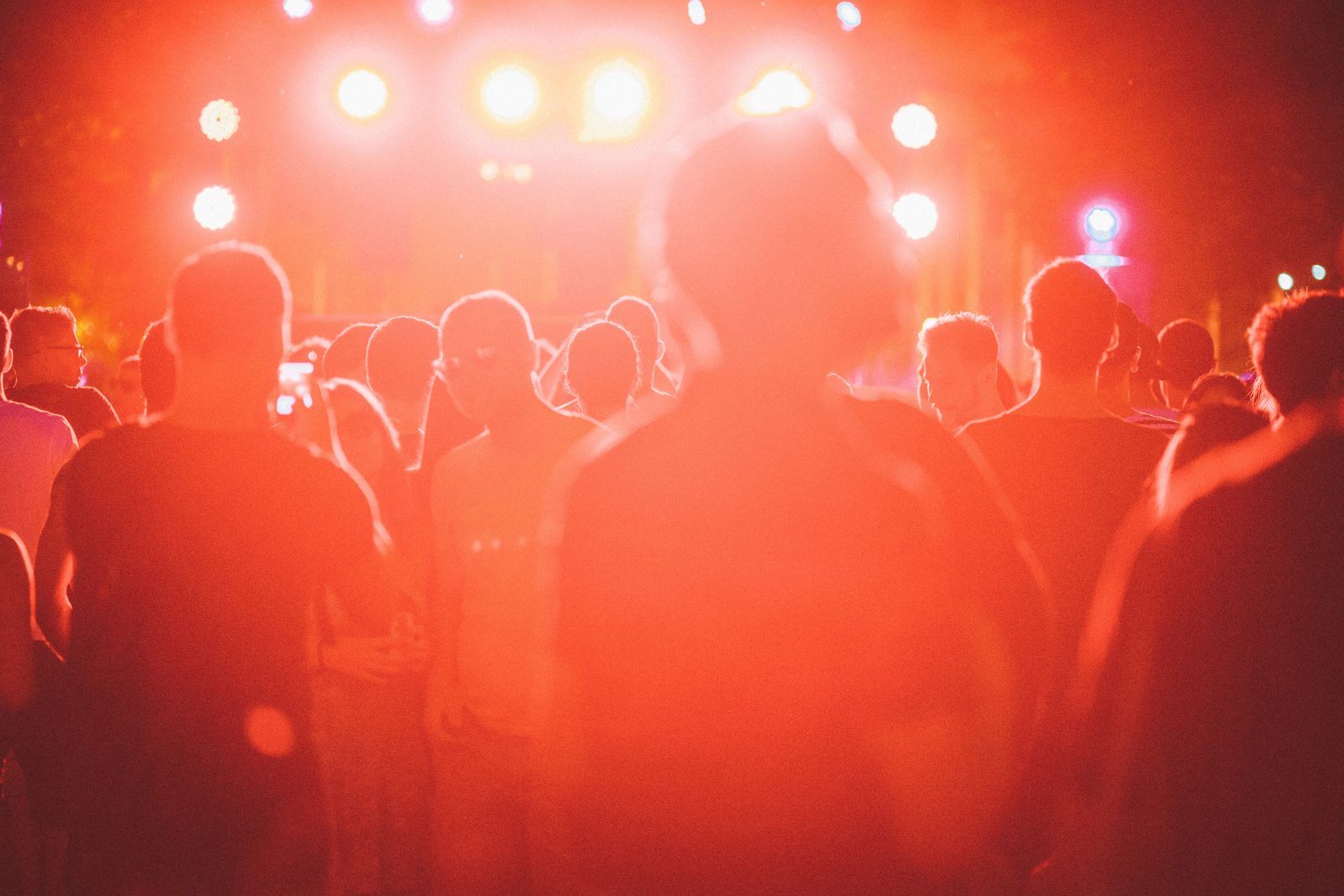 Crowd with hands raised at an outdoor music festival at dusk in Tulum
